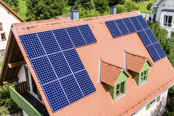 Auf einem Hausdach sind moderne Solaranlagen zur umweltfreundlichen Stromerzeugung installiert.