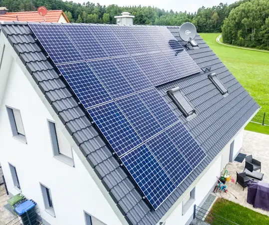 Solaranlage mit Photovoltaik-Modulen auf dem Dach eines Einfamilienhauses zur Stromerzeugung.