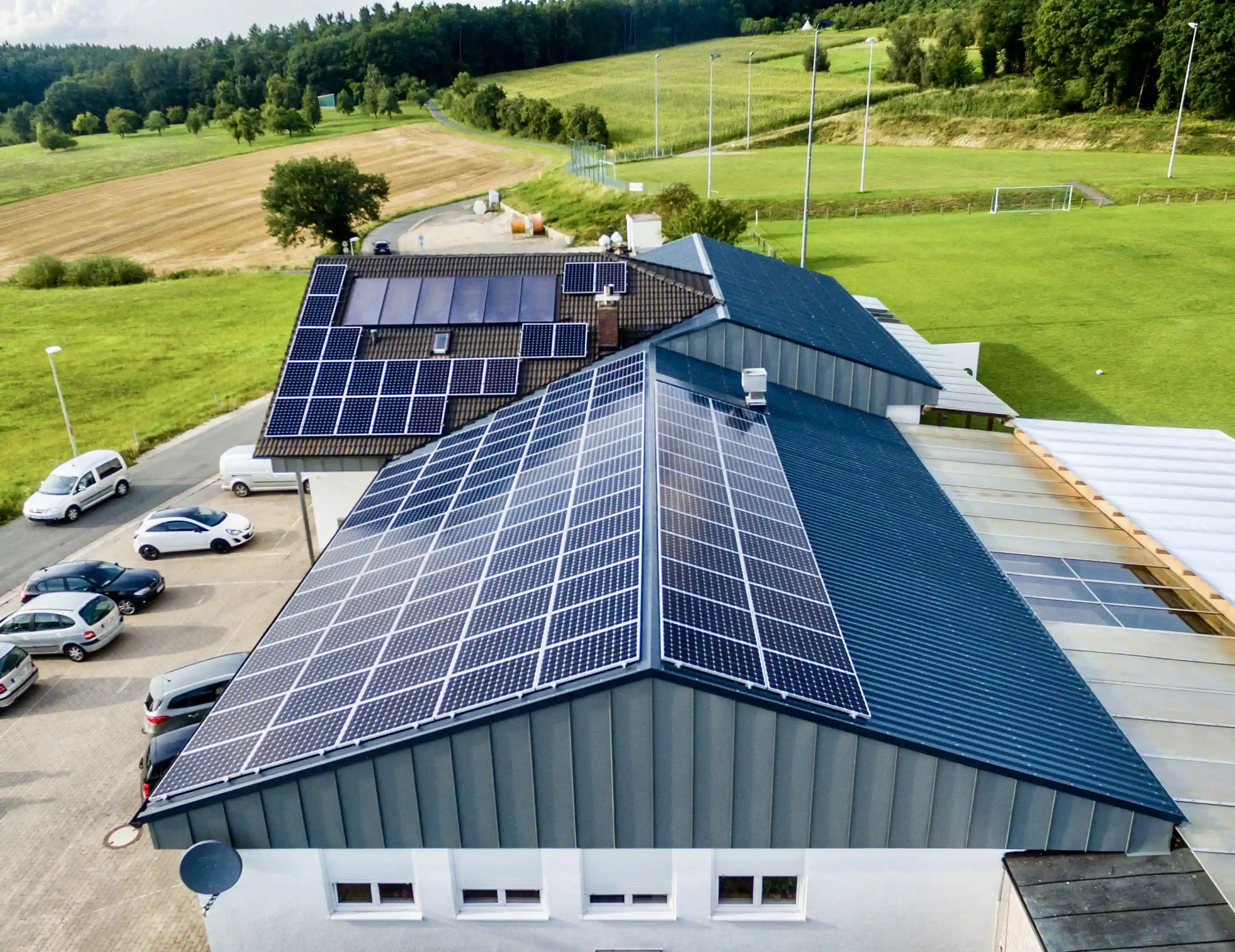 Auf dem Dach eines modernen Gebäudes sind zahlreiche Photovoltaik-Solaranlagen zur Stromgewinnung montiert.